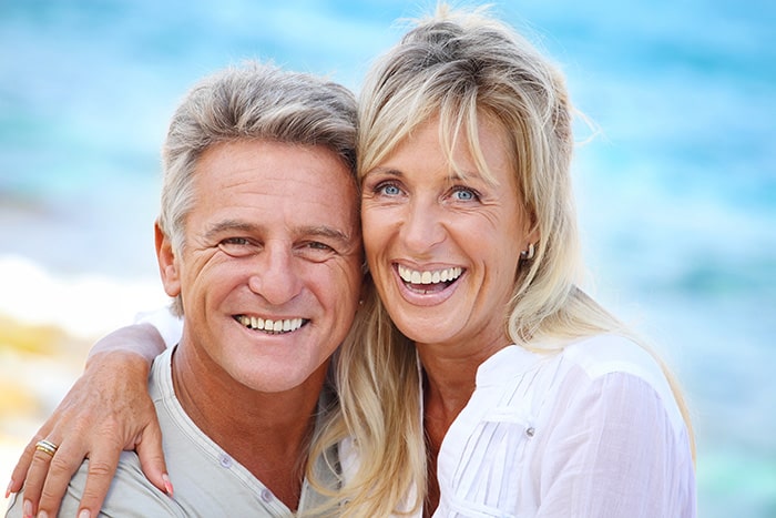 couple are smiling after their dental implant